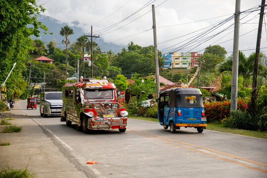 June 13, 2025: Jeepney and Tricycle on Busy Street in Puerto Galera, Philippines, Local Public Transportation Scene
