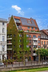 Explore sustainable architecture in Antwerp, Belgium. This eco-friendly building features a green facade and solar panels, merging modern design with nature in the heart of the city.