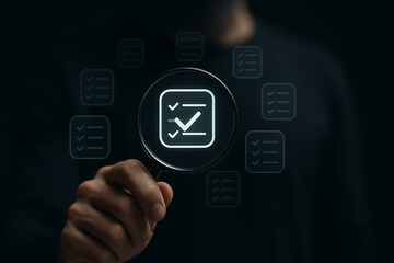 Close-up of hand holding magnifying glass focusing on digital checklist icon, symbolizing document validation, quality assurance, and auditing process in modern digital workflow
