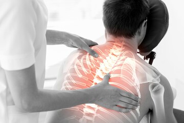 Rear view of injured man having back massage
