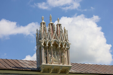 The Madonna with Child sculpture on top the roof of the Camposanto entrance, Square of Miracles in Pisa, Italy.