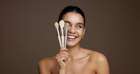 Happy woman, makeup and beauty with brushes in studio for cosmetics on a brown background. Female person, model or smile with product tools for cosmetology, foundation or blending shade on space