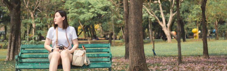 asian woman solo traveler relax and enjoy to see pink cherry blossom blooming from springtime road trip