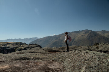 Obraz premium Persona posando en la meseta de la montaña de Marcahuasi con una laguna delante de él mirando el horizonte con un cielo despejado 