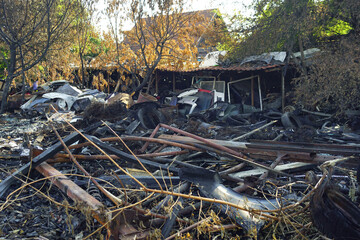 Scrap metal and vehicle remnants after fire in junkyard. A burnt-out area that housed a local used...