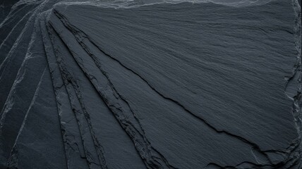 Stacked dark slate sheets with natural textures and subtle light reflections