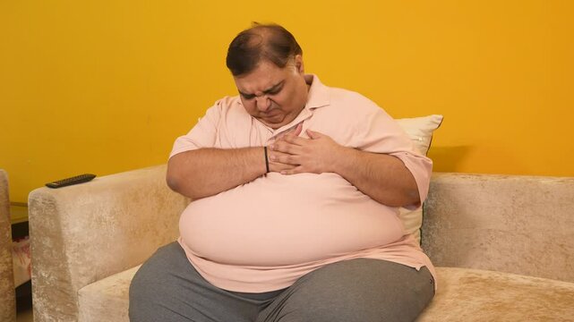 Obese indian man suffer from chest pain at home. Overweight fat guy heart attack symptoms. healthcare and medical emergency condition.4k