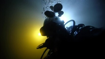 Underwater exploration of a scuba diver illuminated by vibrant lights in deep ocean depths