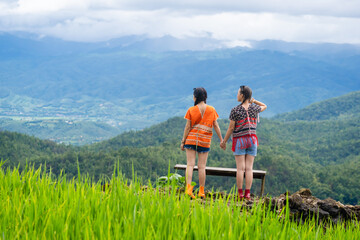 Group of pretty teenage travellers wearing custom-made Karen dresses in a natural green terraced rice fields at Pa Bong Piang rice fields, Mae Chaem, Doi Inthanon, Chiang Mai, Thailand.