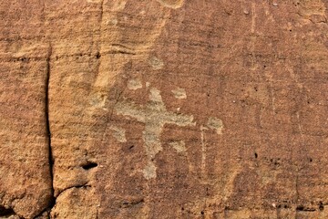 Petroglyph of a cross and dots at Aztec Arches area, New Mexico.