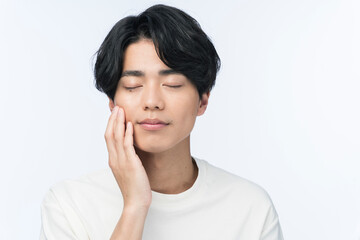 頬に手を当てている若い日本人男性