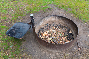 Photograph of a purpose built steel ringed campground fire pit to ensure safe  use for heating and cooking while located in a large forest at risk of bushfire.