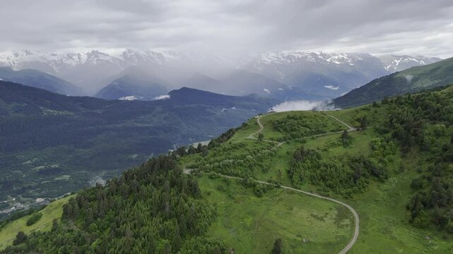 Aerial view of foggy Caucasus mountains near Koruldi Lake in Mestia, Georgia on a cloudy day