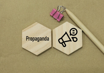 Propaganda word and icon concept with flat lay design of wooden blocks