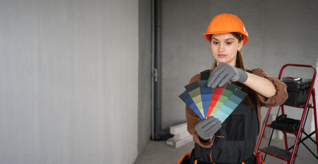 Repairwoman or house painter woman choose the color using the sample swatch renovate house