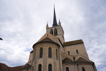 Looking up abbey church at Swiss city of Payerne on cloudy spring day. Photo taken June 6th, 2025, Payerne, Switzerland.