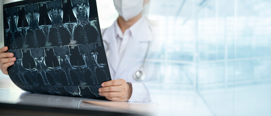 Orthopedist checkup cervical spine x-ray film and diagnose cervical spondylosis at doctor room with...