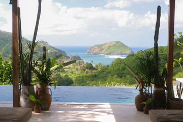 View from a luxury villa with a terrace and an infinity pool to the ocean and hills around the island. Tropical resort for honeymoon, peace and quiet. Romantic vacation.