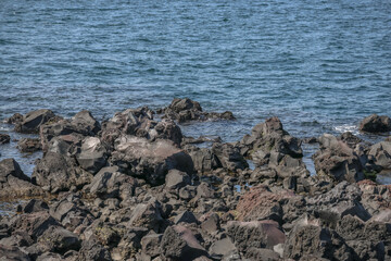 March 23 2025 Rocky Shoreline with Waves Crashing Against Black Volcanic Rocks, Japan