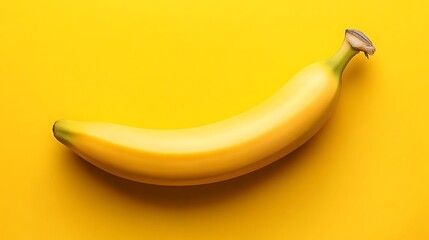 Single banana on a bright yellow surface.