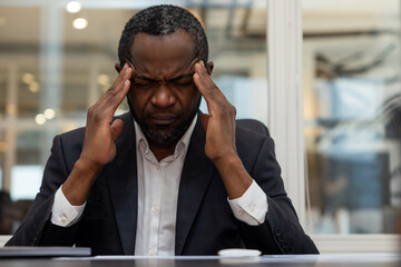 African american businessman having a headache after a busy working day