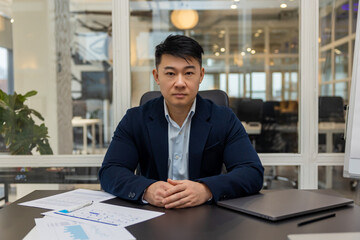 Asian young businessman working in his office and looking busy