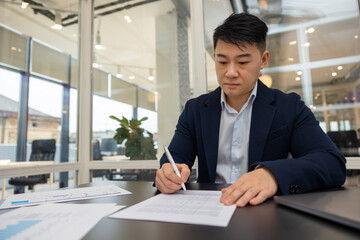 Young asian manager working on a new project and looking busy