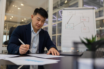 Young asian manager working on a new project and looking busy