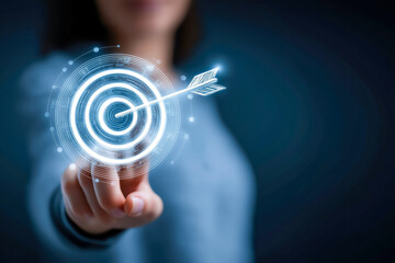 A person reaching out towards a digital target graphic with an arrow, symbolizing goals and achievements.