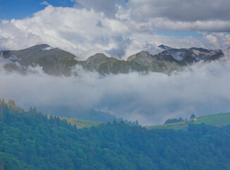 mountain chains in dense mist and clouds, summer mountain travel scene