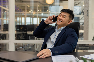 Asian young manager having a phone call and looking busy and involved