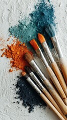 Artistic Paintbrushes and Colorful Pigment Powders on a Light Gray Surface