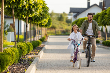 Fototapeta premium Family cycling adventure with father and daughter on home path