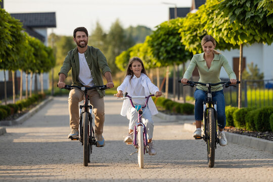 Family enjoying bike walk through neighborhood with greenery