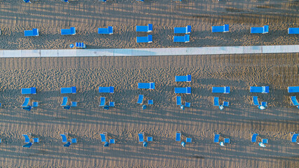 Sun umbrellas and sun loungers on the beach, Tyrrhenian Sea, tourist resort of Viareggio, Italy. View from above
