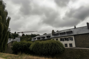 Viewing Stone Buildings with Trees and Crane Against Cloudy Sky. Mock up promotion information for marketing announcements and details, blank white space