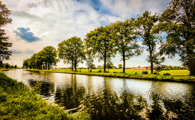 A picturesque river scene, featuring lush greenery and calm waters, all beneath a stunningly beautiful sky