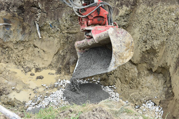 Für einen neuen Trinkwassertank wird ein Fundament mit der Baggerschaufel zementiert
