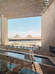 Modern building framing majestic giza pyramids in egypt
