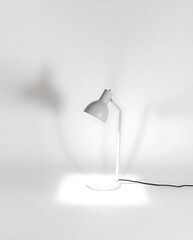 Contemporary white adjustable desk lamp casting soft light on backdrop