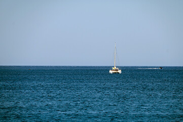 Sailboat gliding across the calm blue waters of Crete, Greece on a sunny day