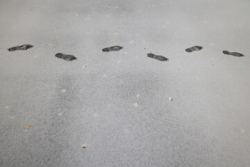footprints of a passer-by on the first winter snow, background, surface texture