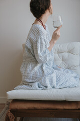 Woman in Casual Attire Holding a Glass of Water