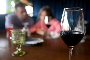 dinner in a restaurant with wine, beautiful table setting, a glass of wine in the foreground
