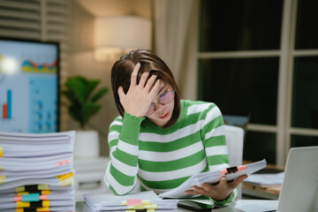 A stressed woman works late at a cluttered desk, surrounded by papers and charts, overwhelmed with...