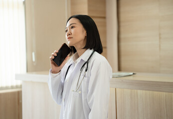 Asia doctor woman use smartphone at hospital