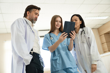 Caucasian woman doctor use tablet computer with team working at hospital	