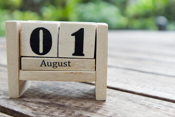 August 01, wooden calendar with cubes on a sunny garden background. Confederation Day