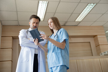Caucasian woman doctor use tablet computer with team working at hospital	