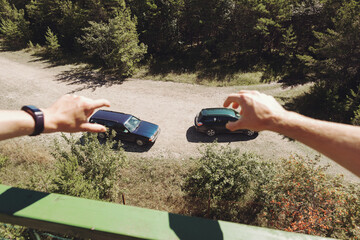 Two man are pretending to hold real cars in their hands. Top view.